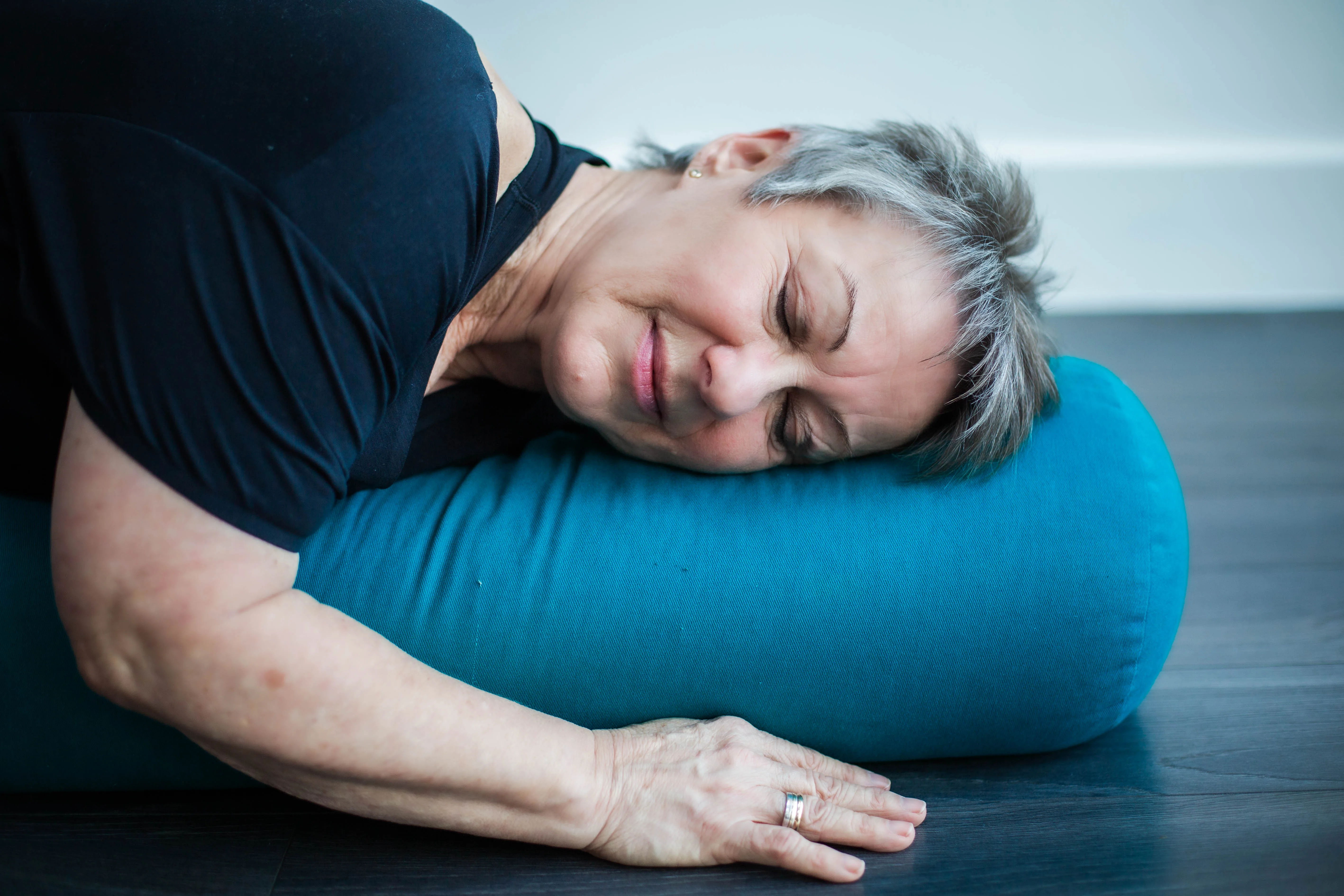 A Phoenix Yoga student resting with support