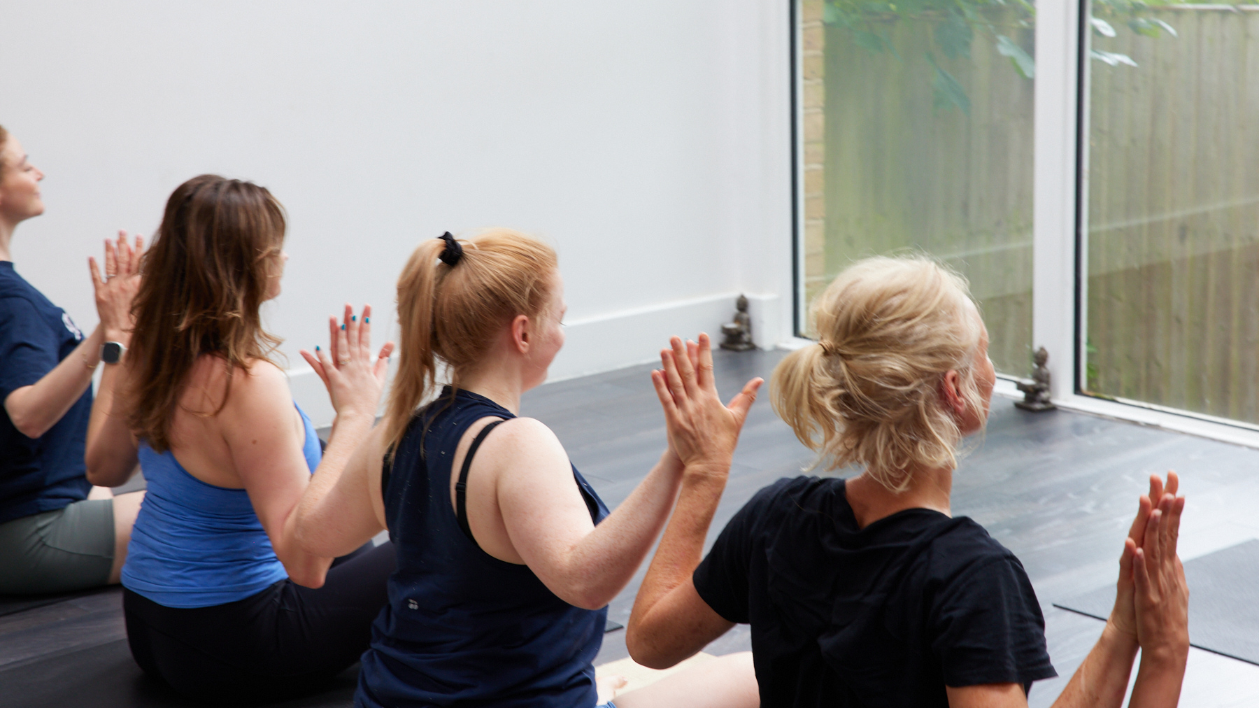 Phoenix Yoga community members raising their hands together