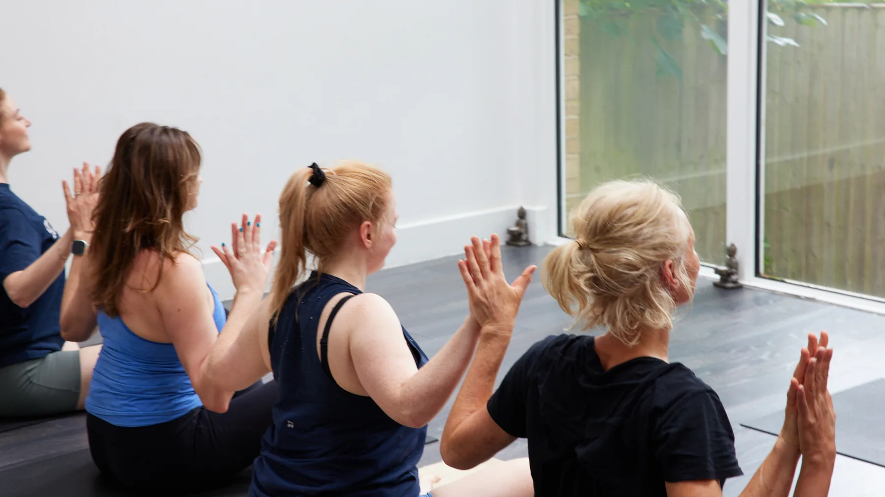Phoenix Yoga community members raising their hands together